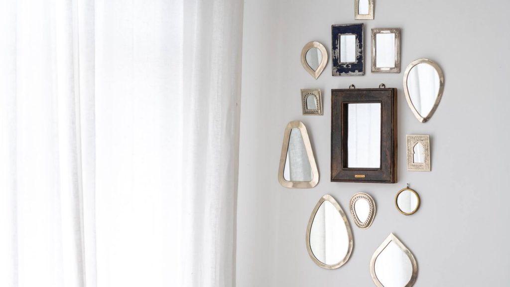 Wall adorned with several mirrors, adding depth and style to the room's decor.