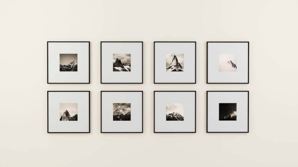 A wall adorned with eight picture frames, showcasing black and white photographs, adding a timeless and artistic touch to the living room.
